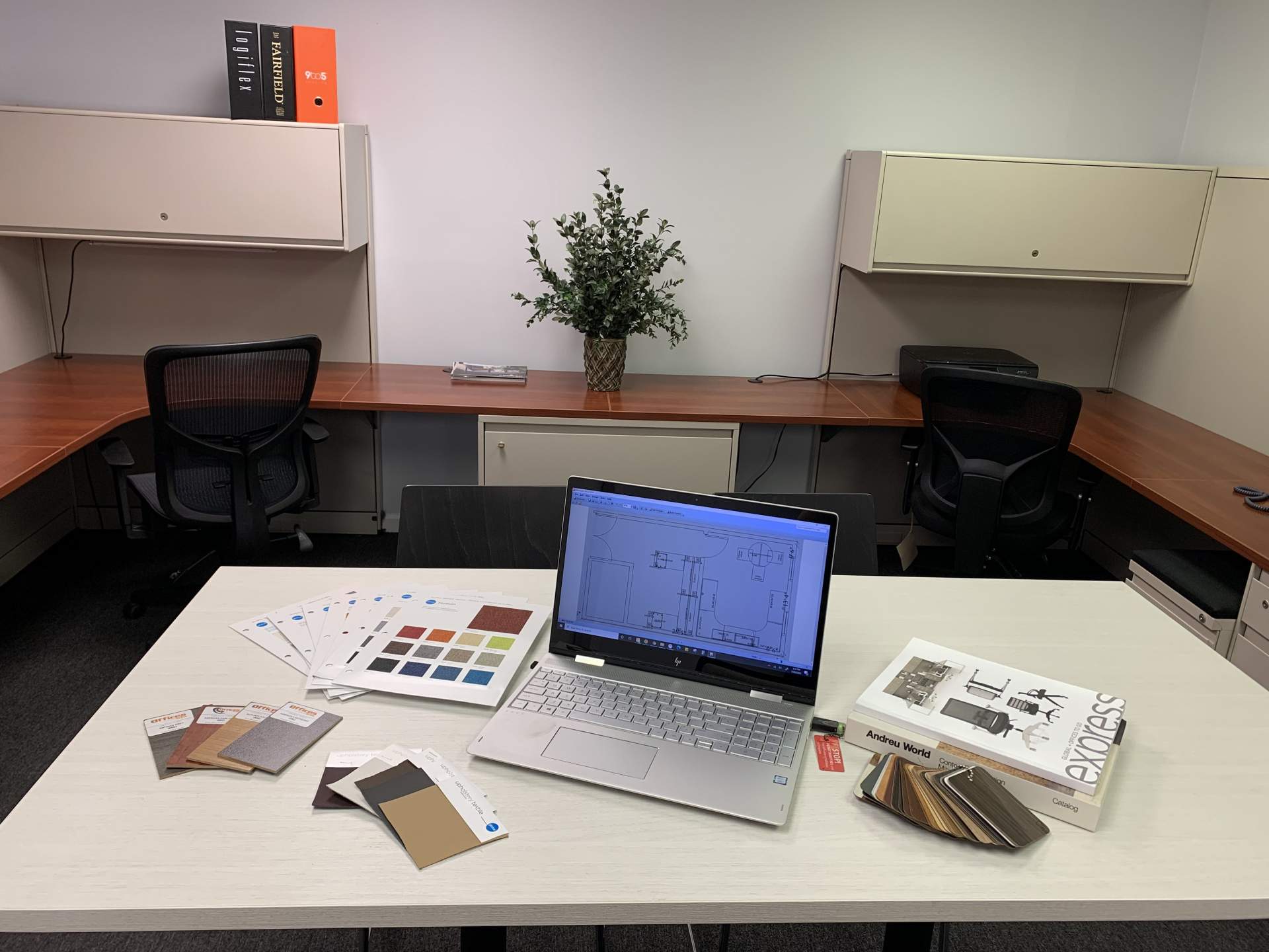 Laptop on desk sitting next to color samples